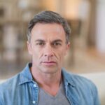 closeup of a middle aged man with a receding hairline contemplating treatment