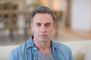 closeup of a middle aged man with a receding hairline contemplating treatment